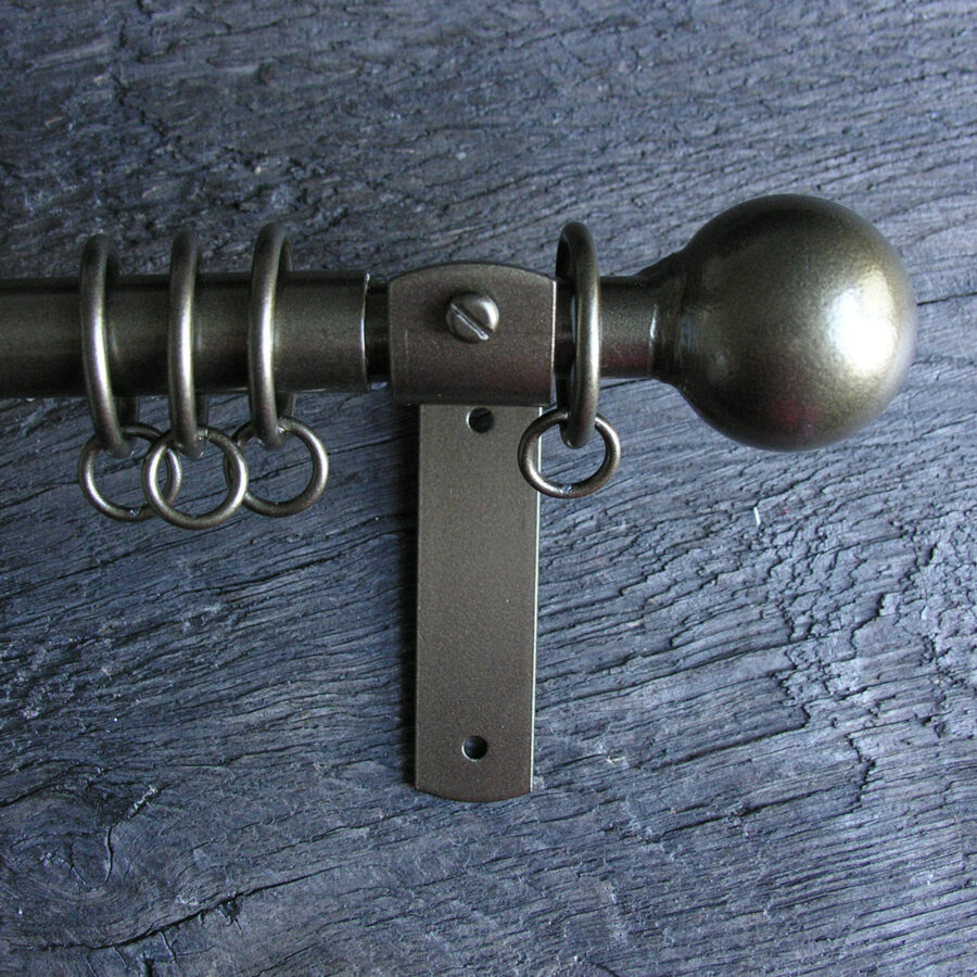 a slim bronze metal curtain pole with ball finials