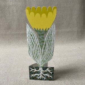 Upright yellow tulip shaped greetings card on a neutral background