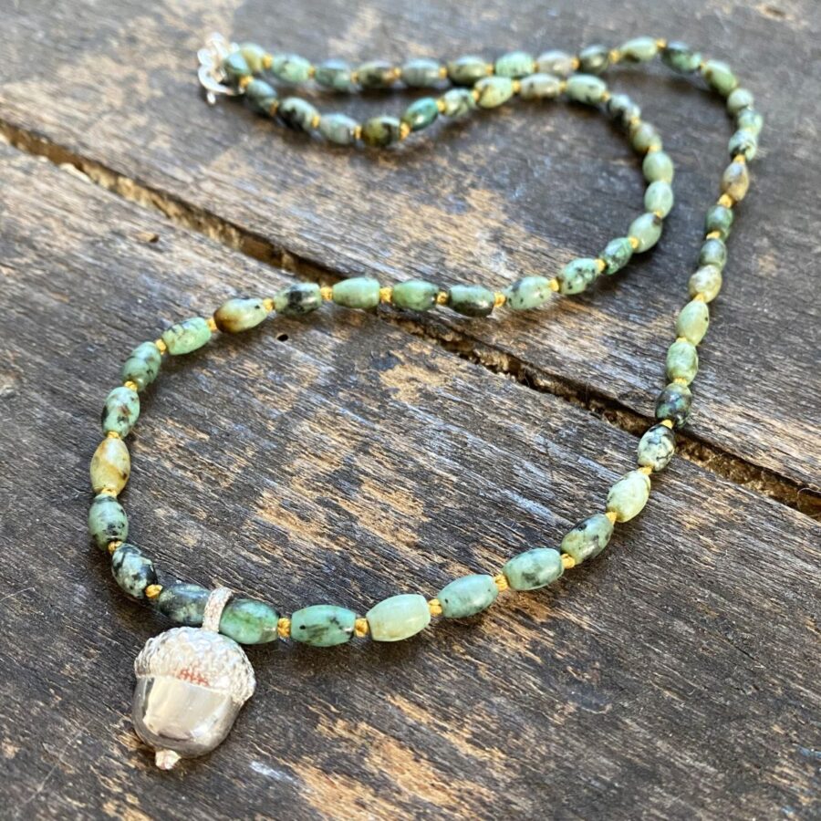African turquoise gemstone necklace by Clare de la Torre on a wooden background