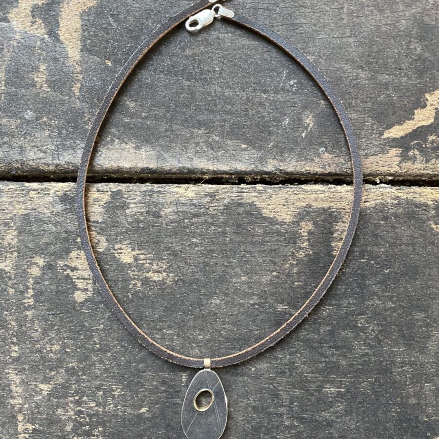 Silver pendant necklace on a wooden background