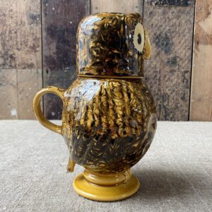 Carole Glover slipware glazed Ozzy Owl against a wooden background