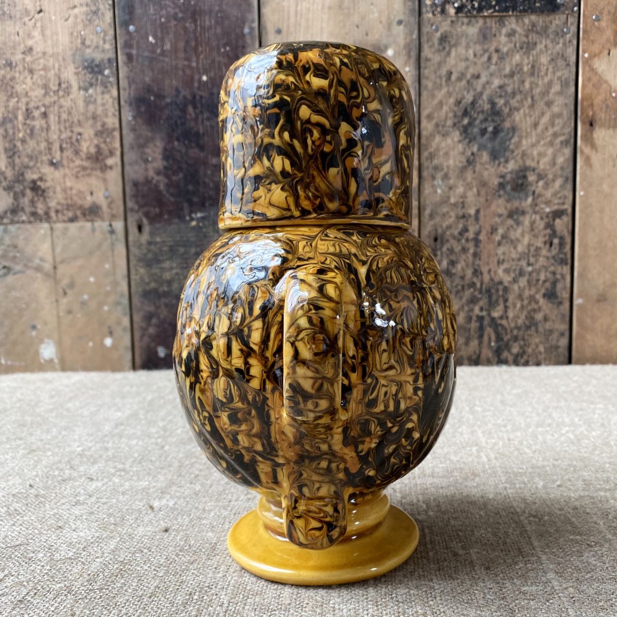 Carole Glover slipware glazed Ozzy Owl against a wooden background