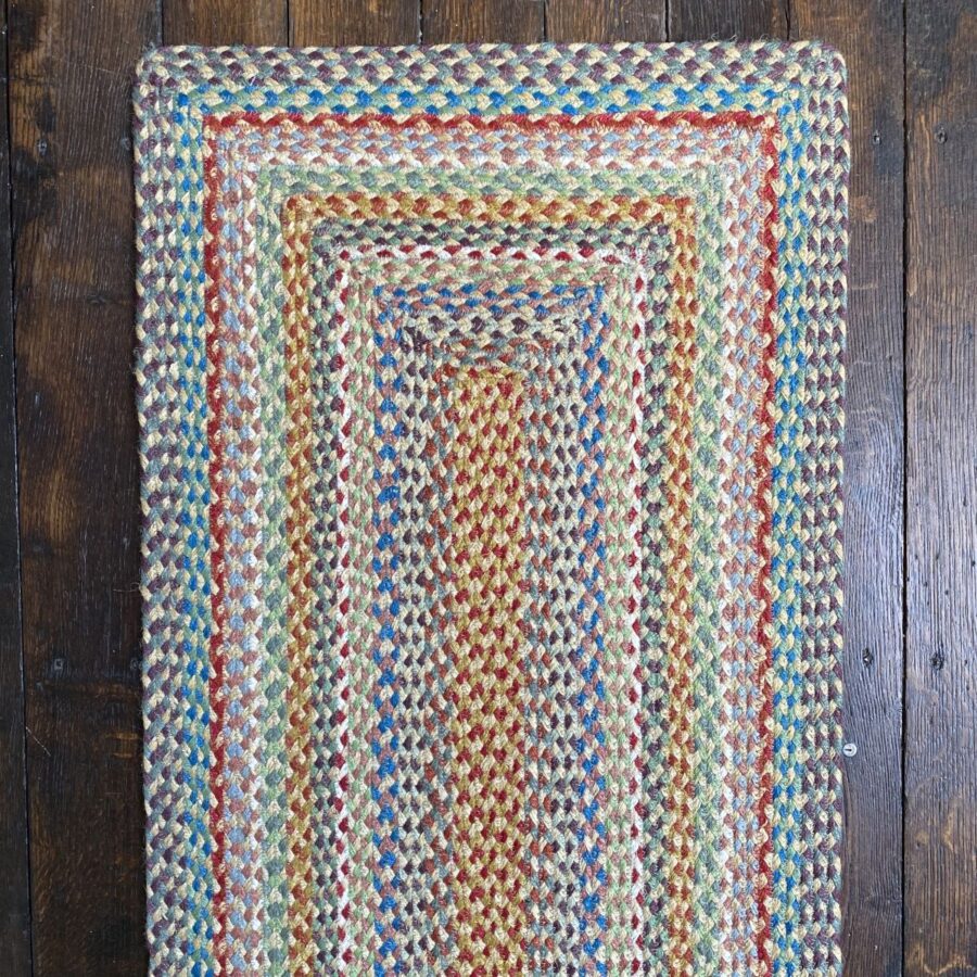 Braided jute runner lying on a wooden floor with a wooden chair on top