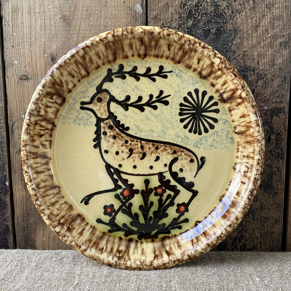 Ceramic slipware plate with stag design on cream base by Paul Young
