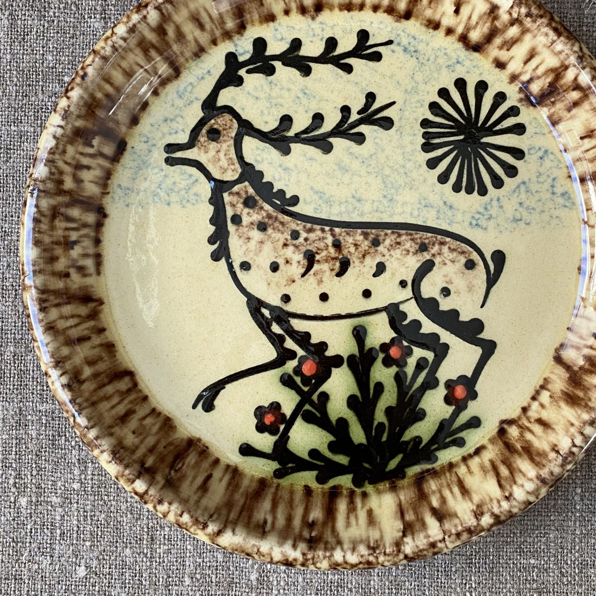 Ceramic slipware plate with stag design on cream base by Paul Young