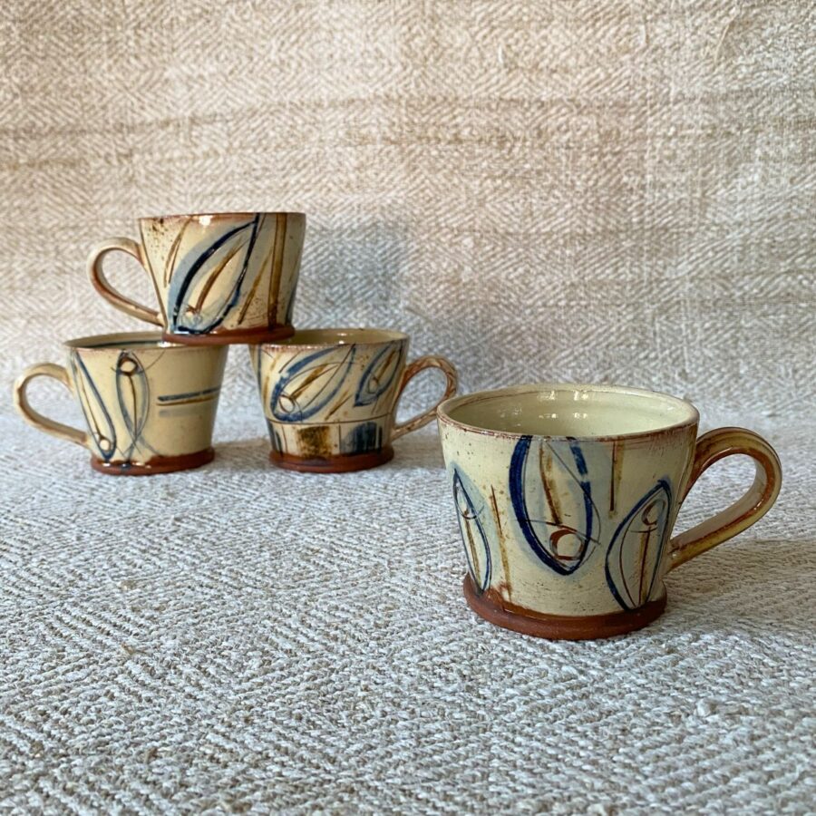 Jennifer Hall stack of slipware glazed espresso mugs on a cream textile background
