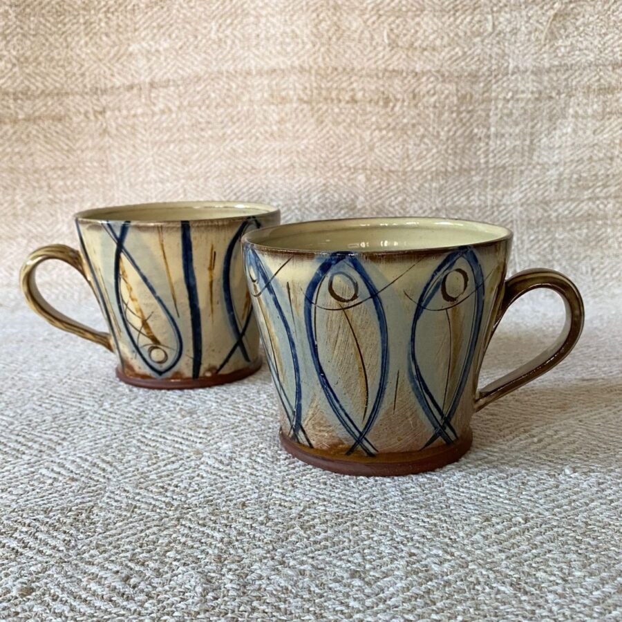 Jennifer Hall pair of slipware glazed espresso mugs on a cream textile background
