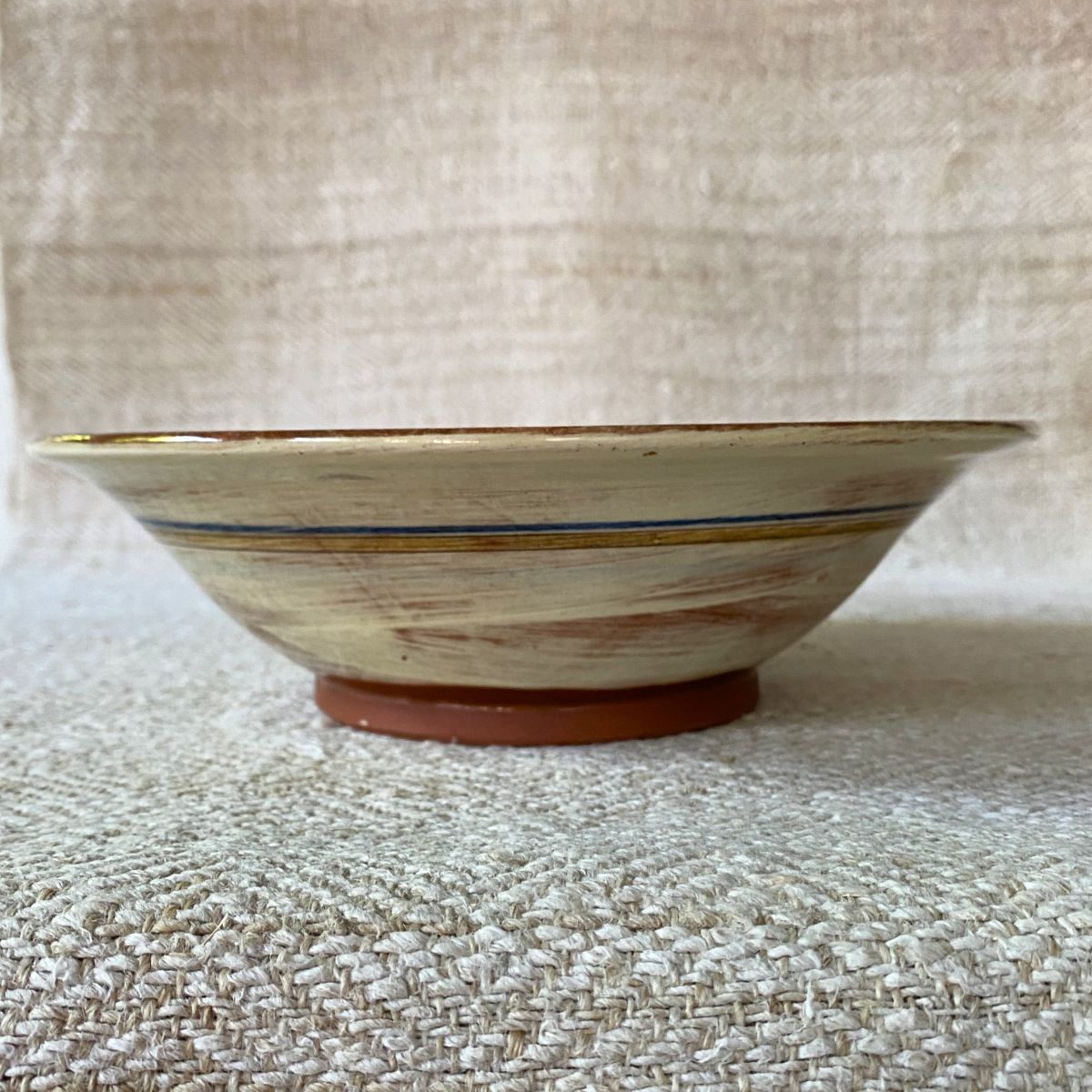 Jennifer Hall Slipware pasta bowl from the side on a cream textile background