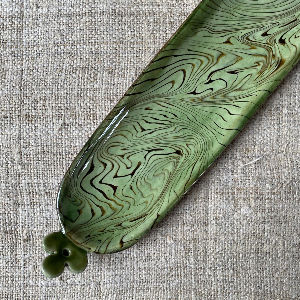 Patia Davis extra long oval platter with green glaze on linen backcloth