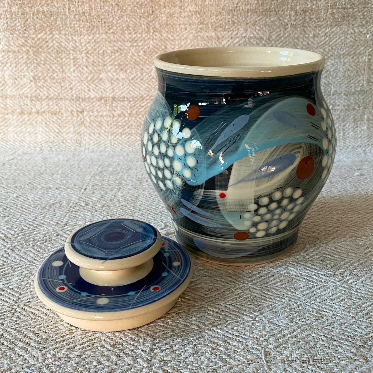 RAMP Ceramics earthenware caddy jar in a blue abstract design on a cream textile backdrop.