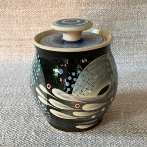 RAMP Ceramics earthenware caddy jar in a blue abstract design on a cream textile backdrop.