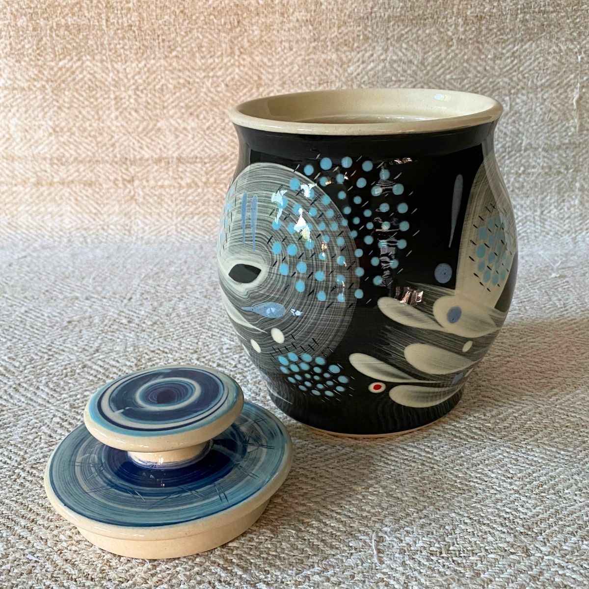 RAMP Ceramics earthenware caddy jar in a blue abstract design on a cream textile backdrop.