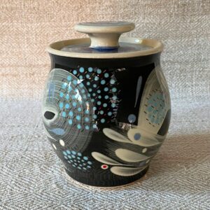 RAMP Ceramics earthenware caddy jar in a blue abstract design on a cream textile backdrop.