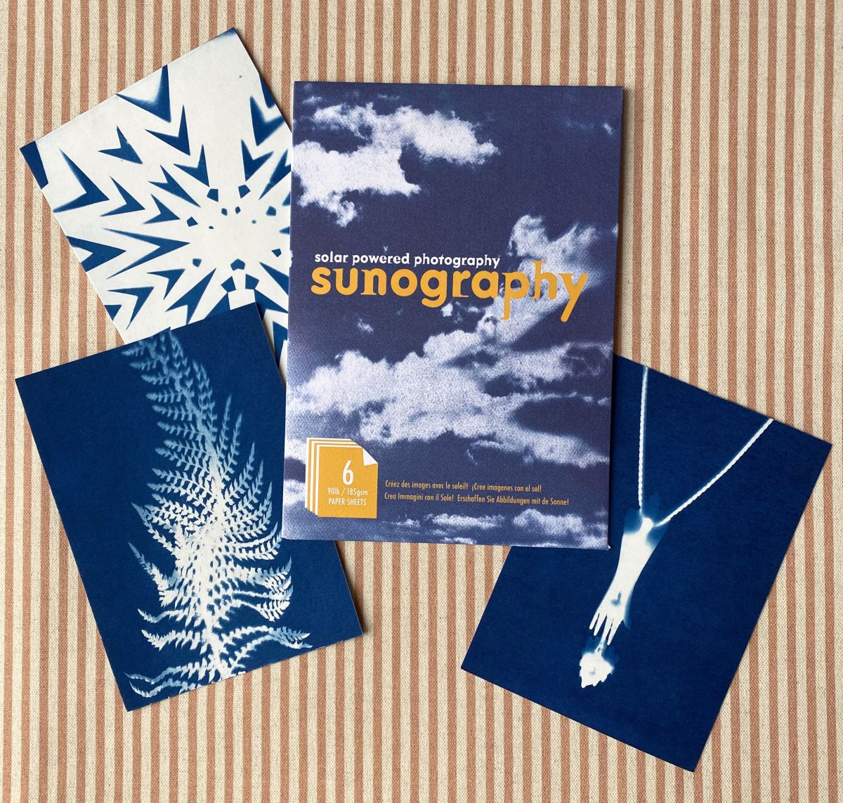 Cyanotype Sunography papers with examples on striped backcloth