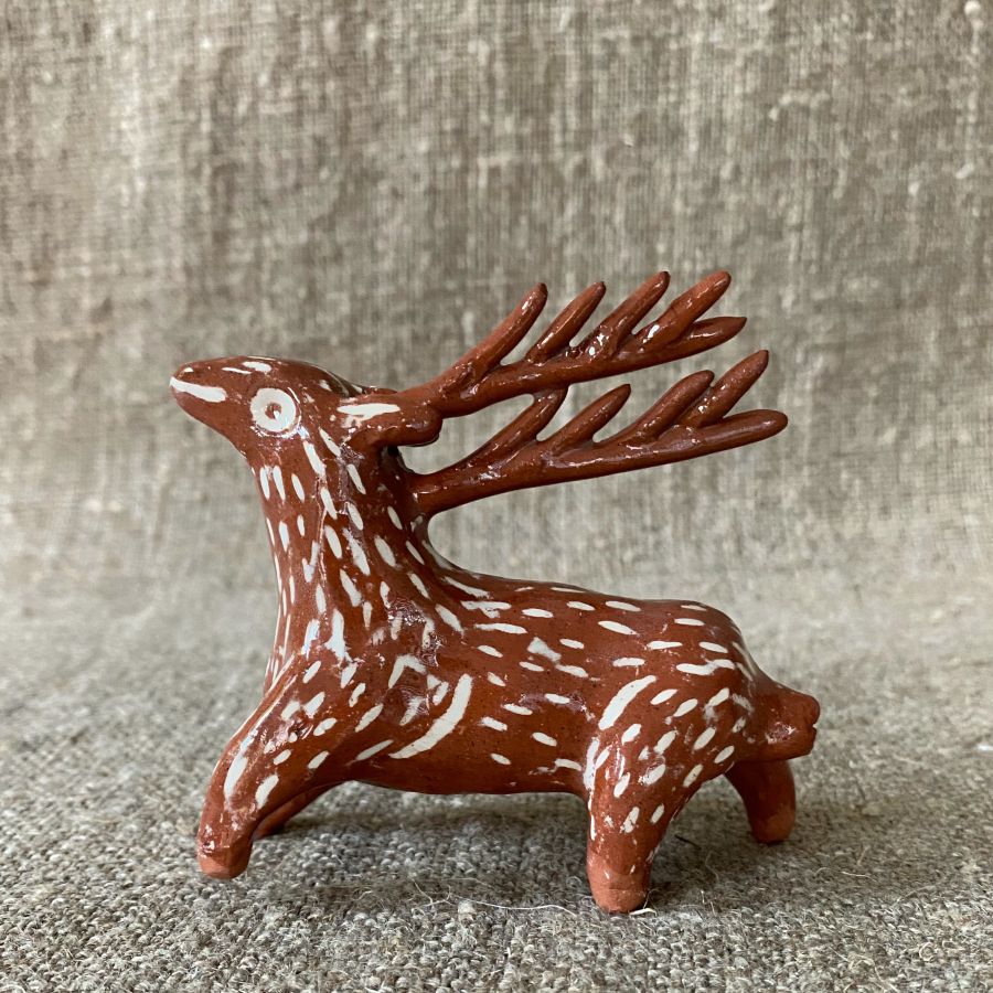 Emma Carlow pottery whistle in the shape of a reindeer against a cloth backdrop