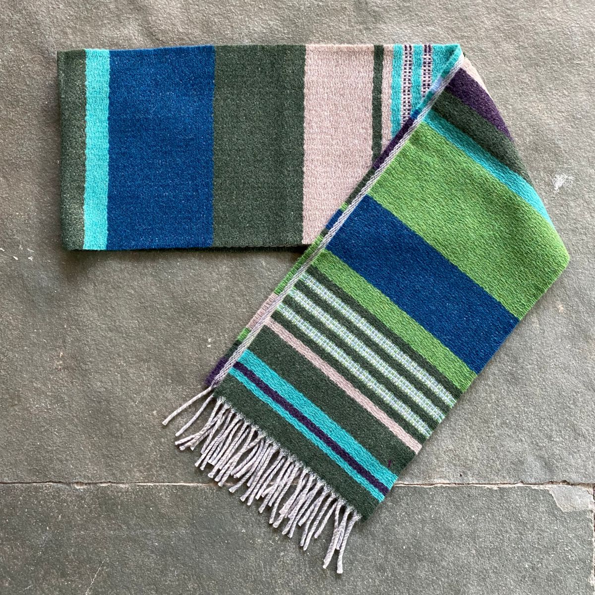Wallace + Sewell striped wool scarf on a stone floor