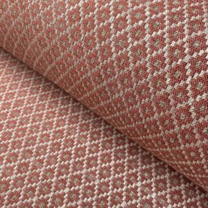 Brick red upholstery fabric with a small diamond shaped pattern in the weave