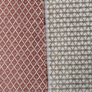 Brick red upholstery fabric with a small diamond shaped pattern in the weave